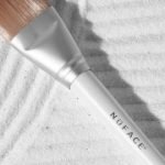 Premium NuFACE Clean Sweep Applicator Brush featuring an ergonomic handle and gentle fibers, perfect for applying serums, creams, and masks with precision.